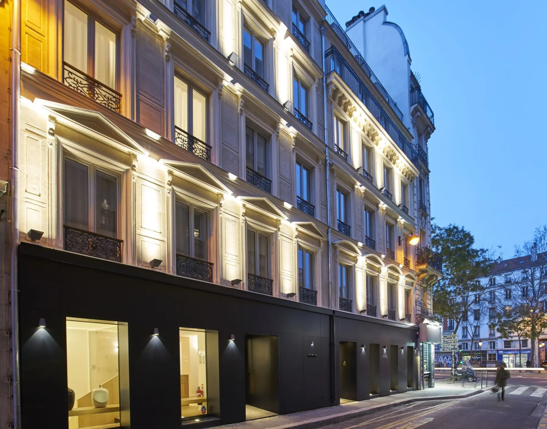 Representative hotel space: A city hotel facade with illuminated windows along a narrow street.