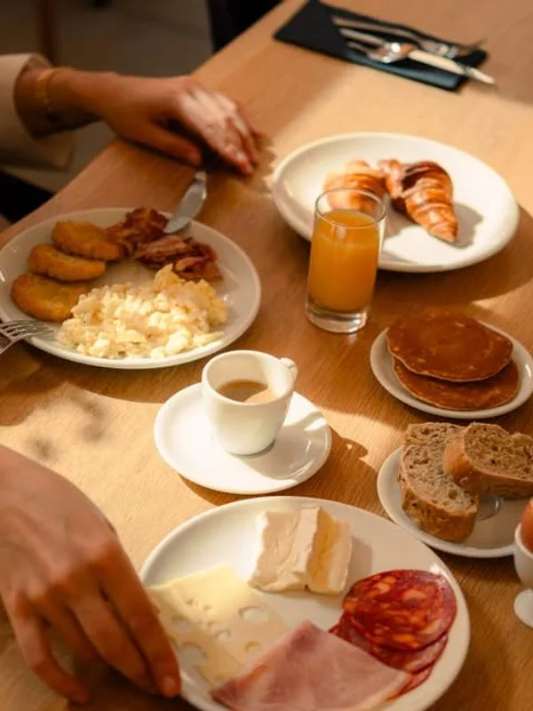 Representative hotel space: A breakfast table with plates of food, juice, and coffee.