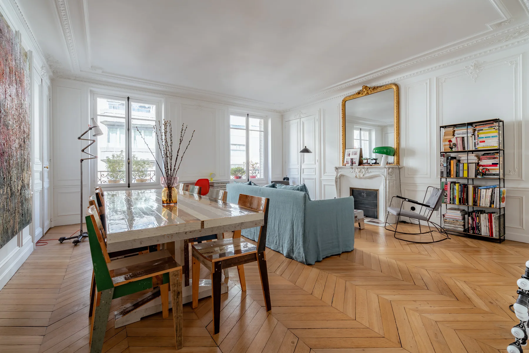 A bright living and dining room with a long table and seating around it.