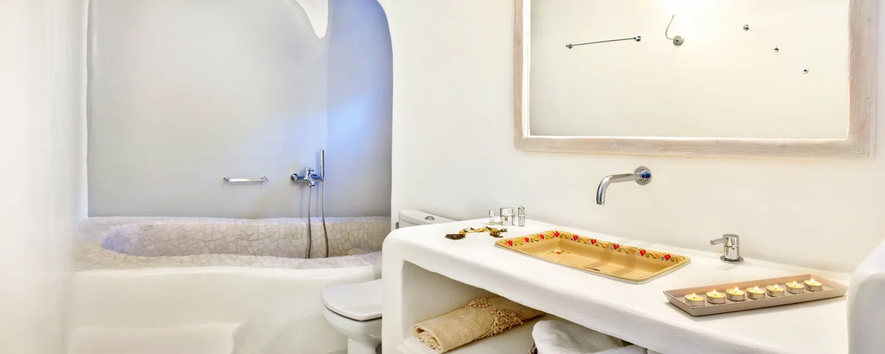 A bathroom with a bathtub, toilet, and long vanity.