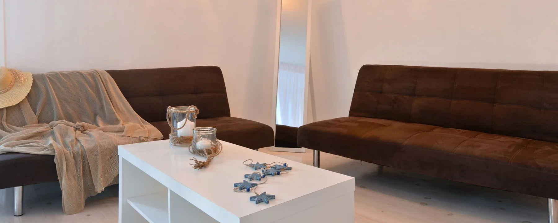 A living room with dark seating and a white coffee table.