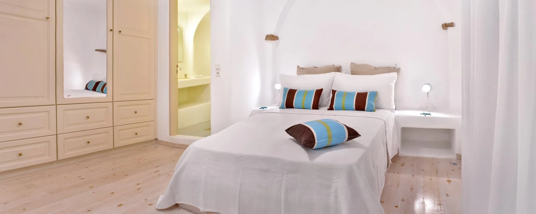 A bright bedroom with a bed and built-in wardrobes.