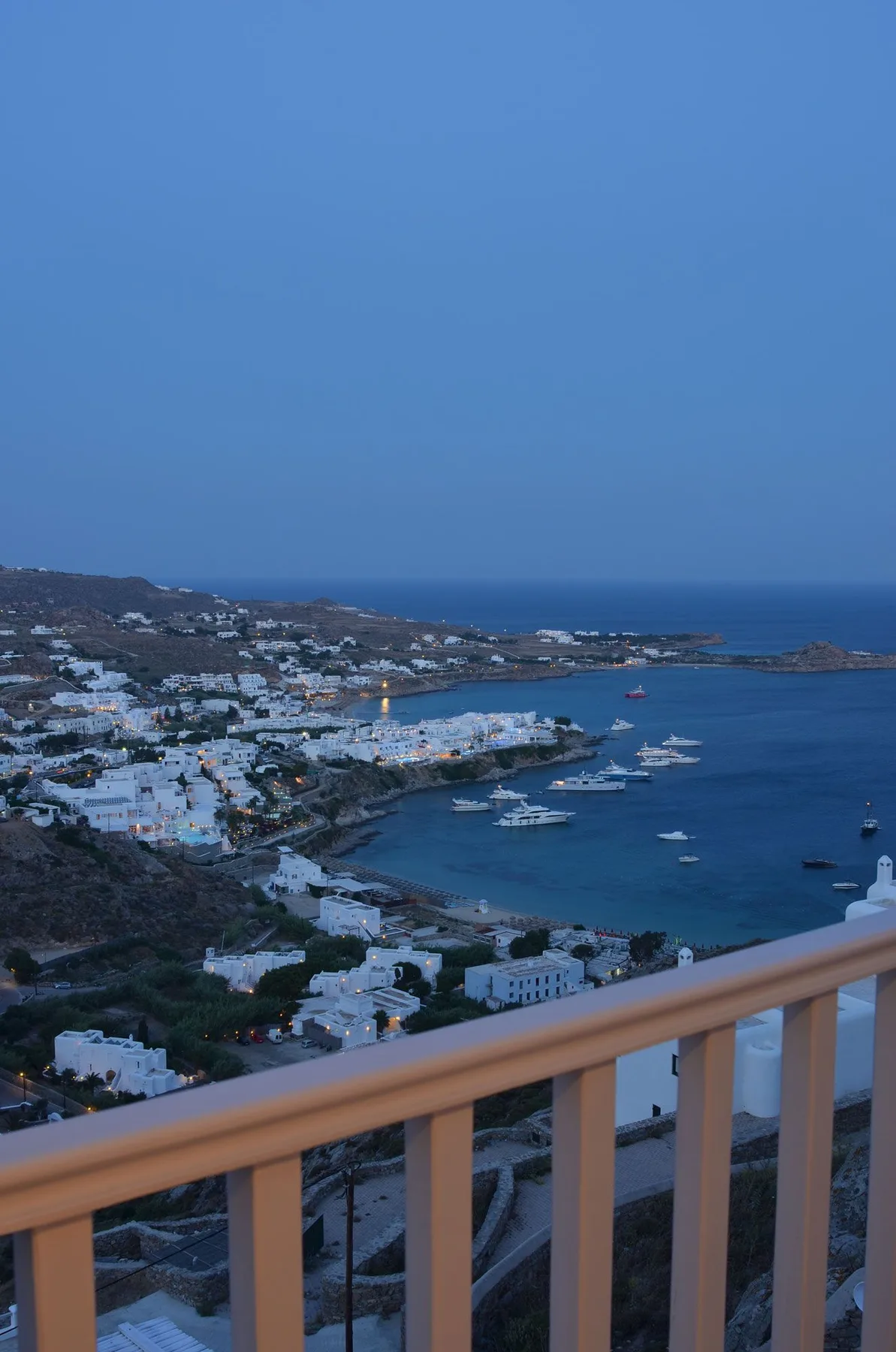 An elevated view of a coastal town and bay, with boats on the water.