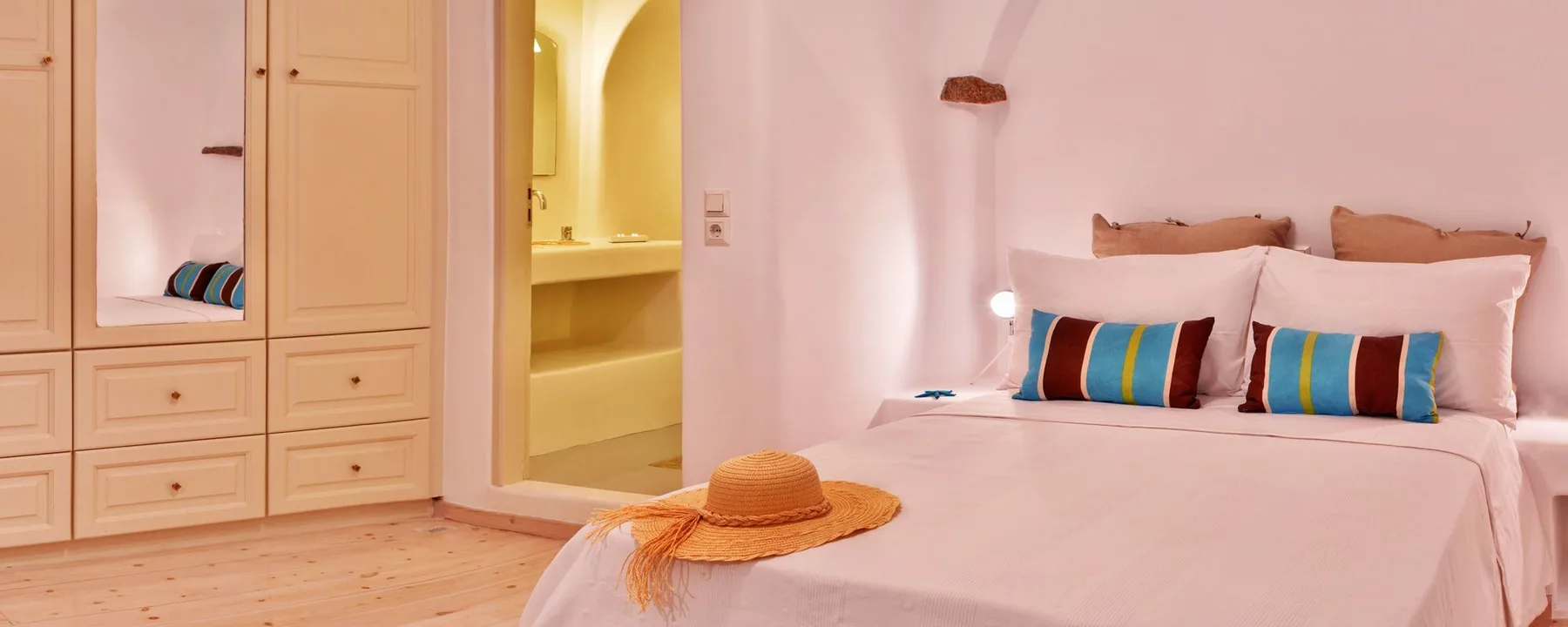 A bedroom with a neatly made bed and built-in wardrobes.