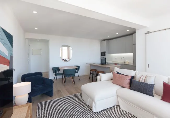 Open-plan living and dining area with a sectional sofa and kitchen.