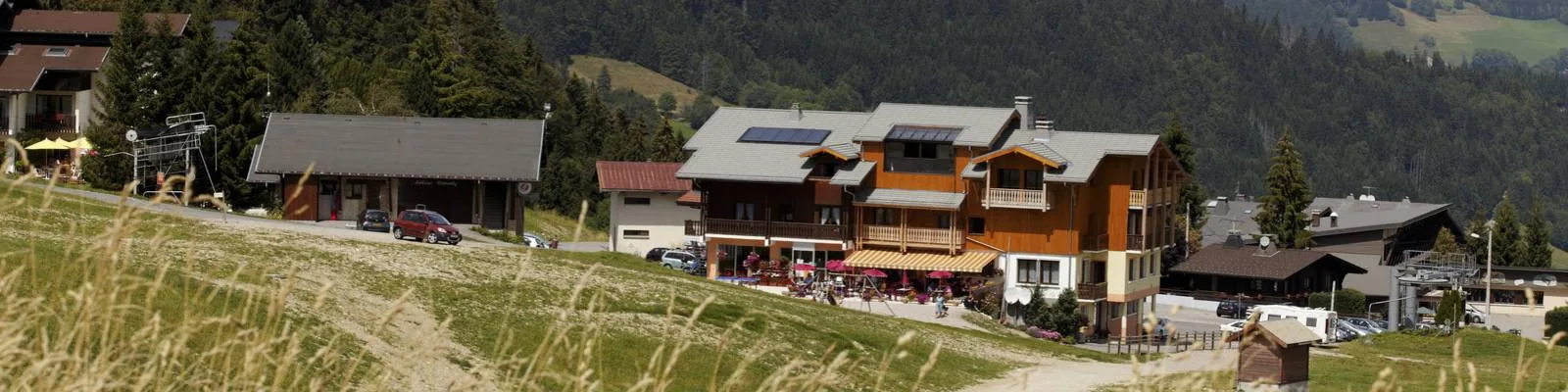 Representative hotel space: A mountain resort complex sits beside a grassy slope.