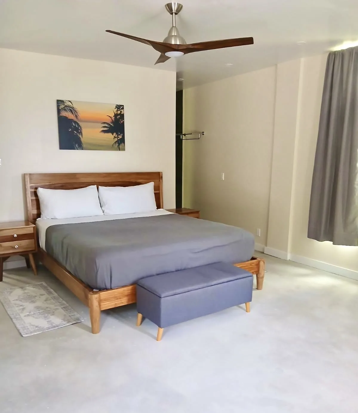 A bedroom with a wooden bed, gray bedding, and a matching upholstered bench.