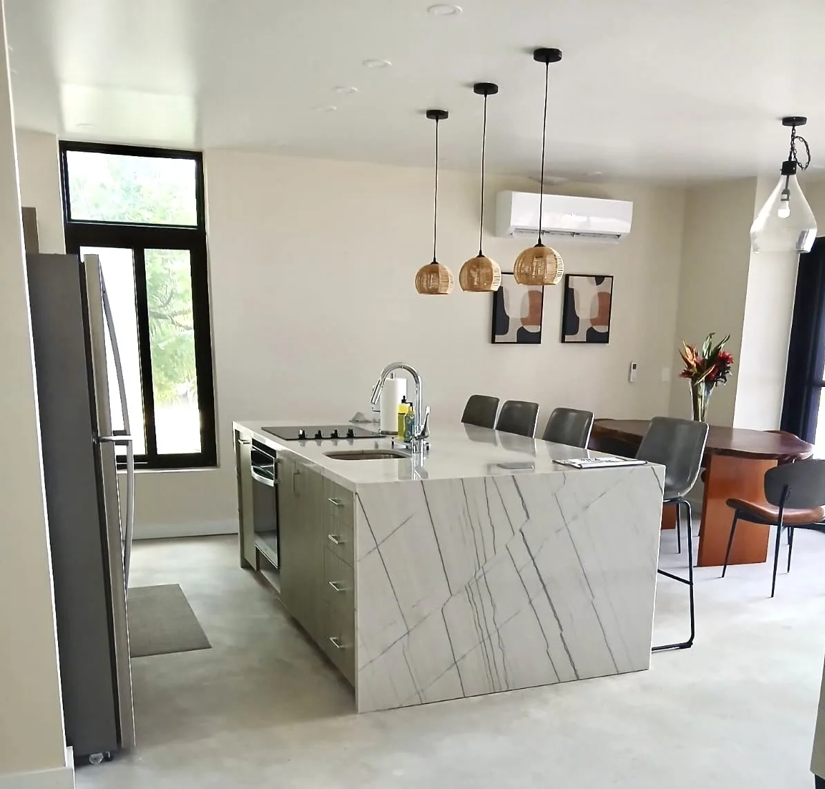 An open-plan kitchen and dining area with a central island and pendant lights.
