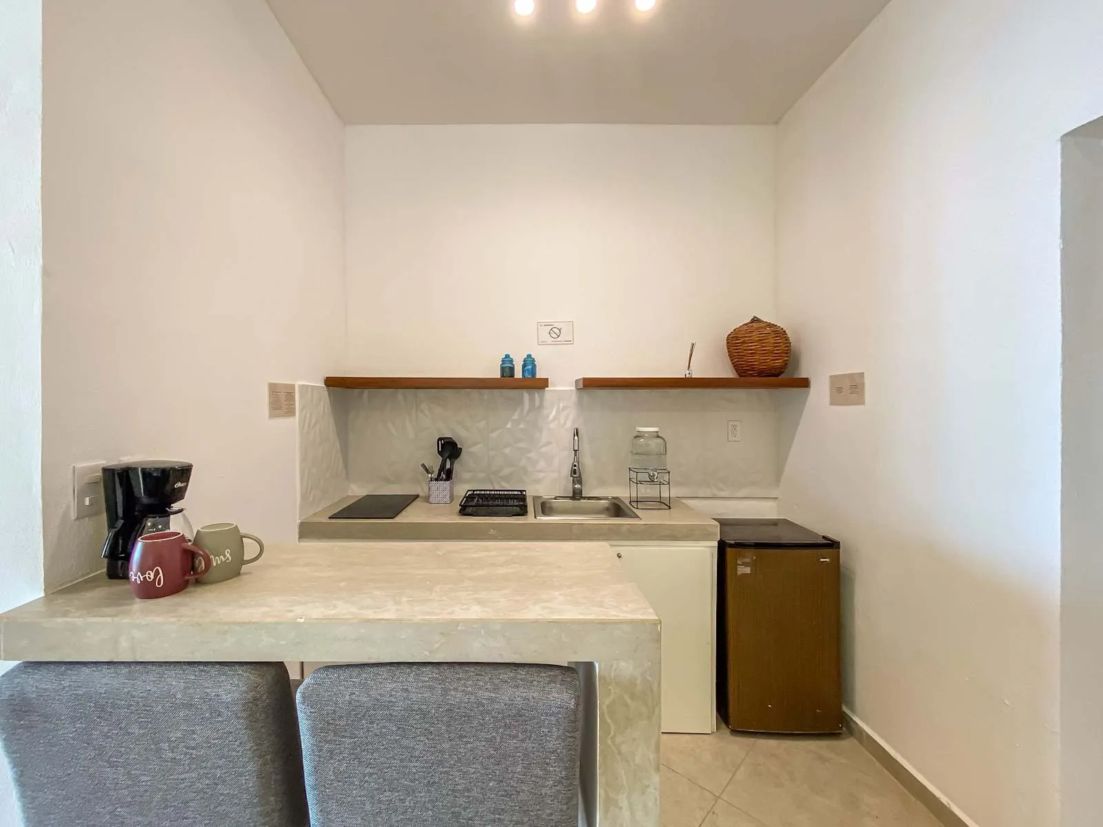 Una cocina compacta con encimera, fregadero y pequeños electrodomésticos.