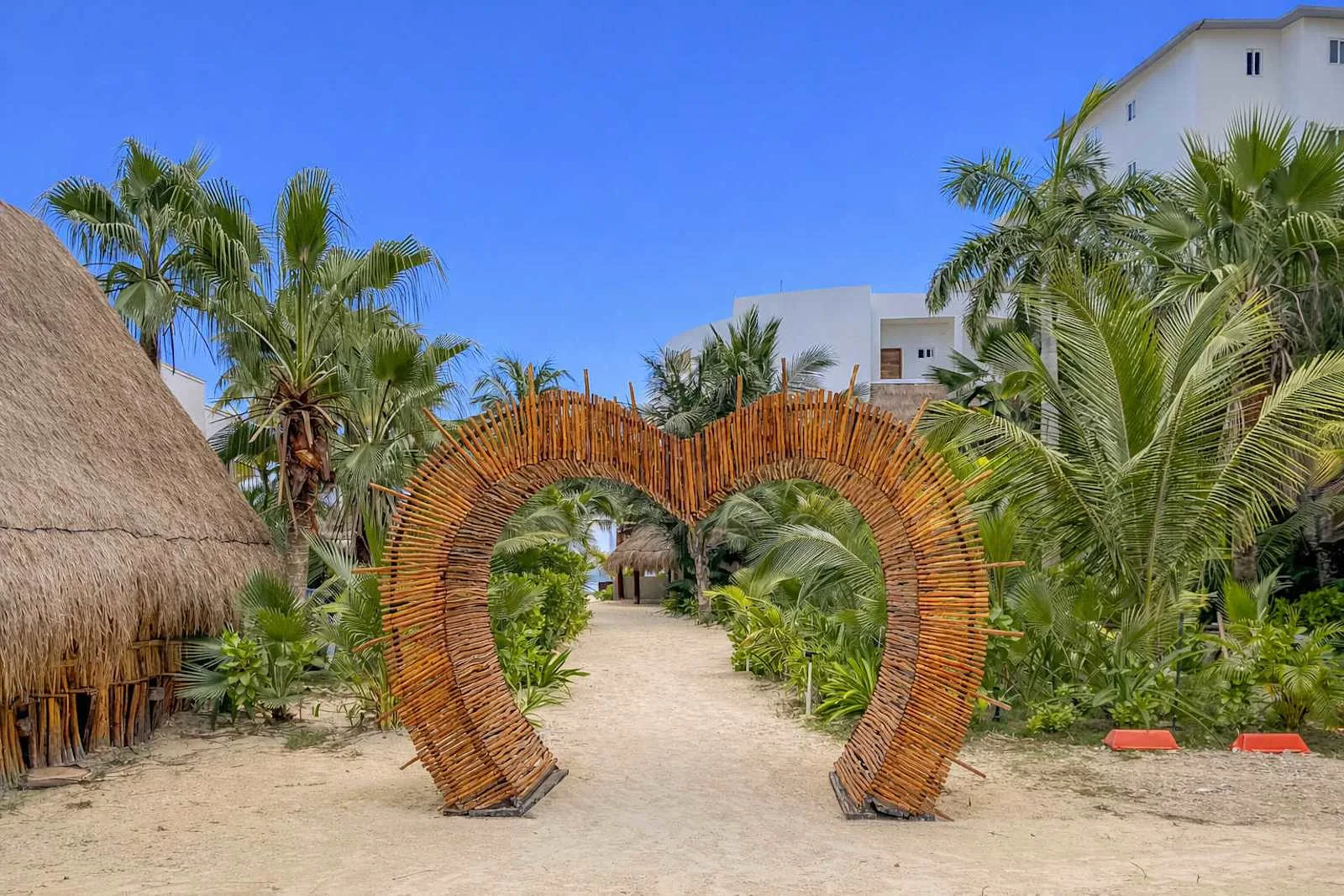 Un sendero de jardín pasa bajo un gran arco de madera en forma de corazón.