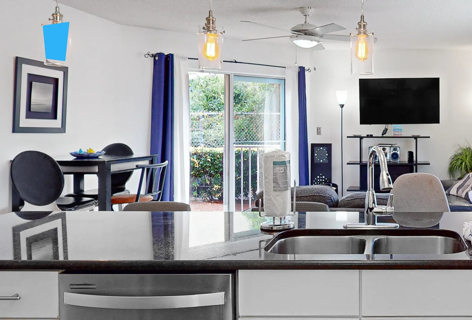 Una cocina y comedor con una barra, una mesa y puertas corredizas de vidrio.