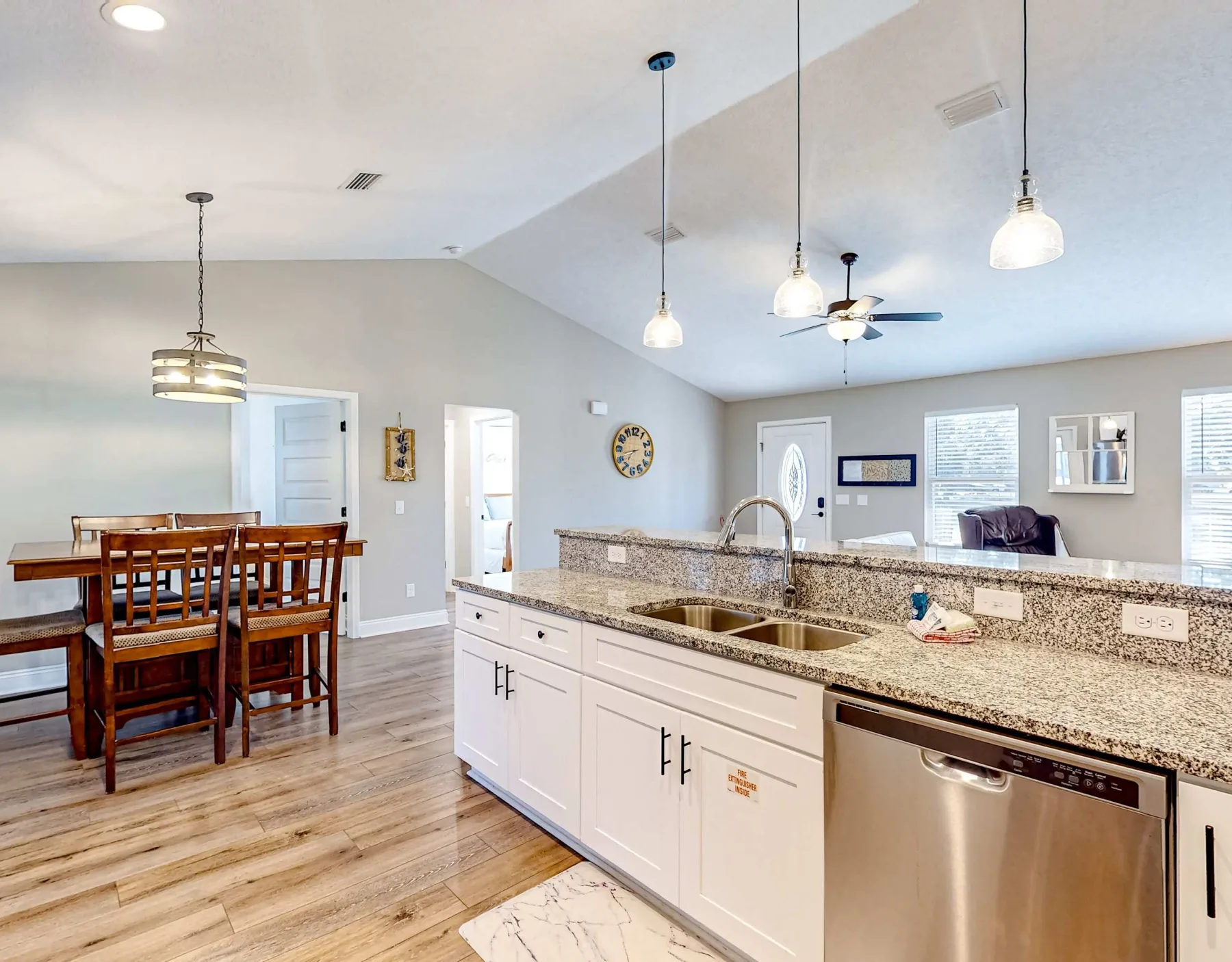 Una cocina abierta y zona de comedor con una barra larga y una mesa de madera.