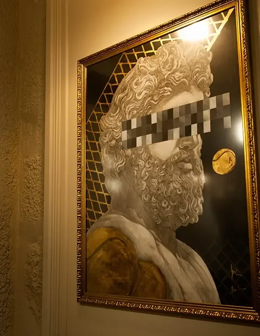 Espacio representativo del hotel: Un retrato enmarcado cuelga de una pared interior con luz cálida.