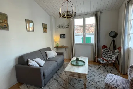 Una sala de estar con un sofá gris y una mesa de centro.