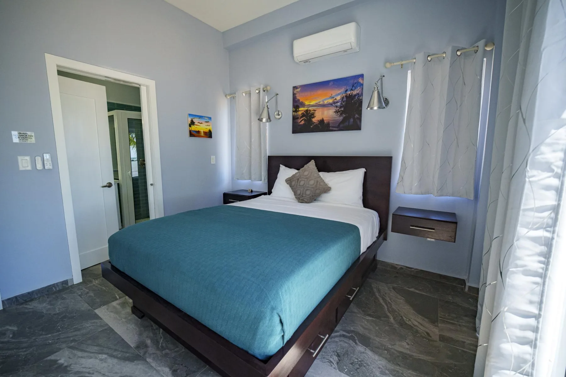 A bedroom with a bed, bedside tables, and curtains.