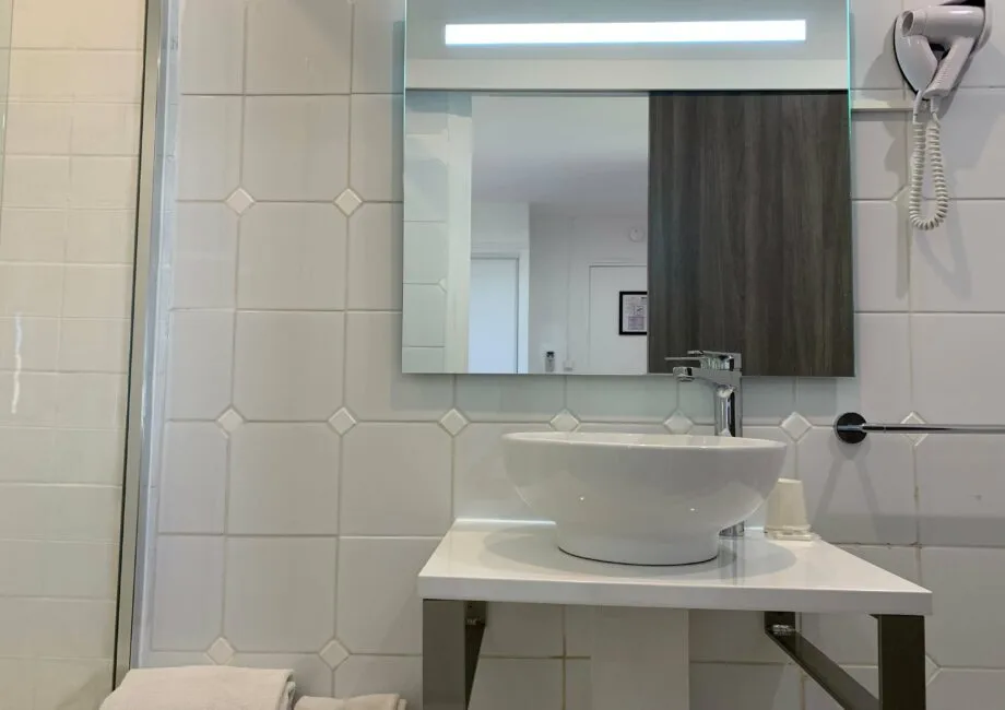 Representative hotel space: A tiled bathroom with a sink beneath a large mirror.