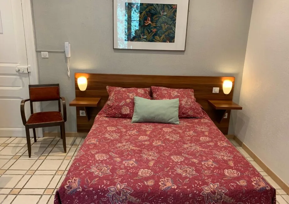 Representative hotel space: A bedroom with a patterned bedspread and bedside lamps.