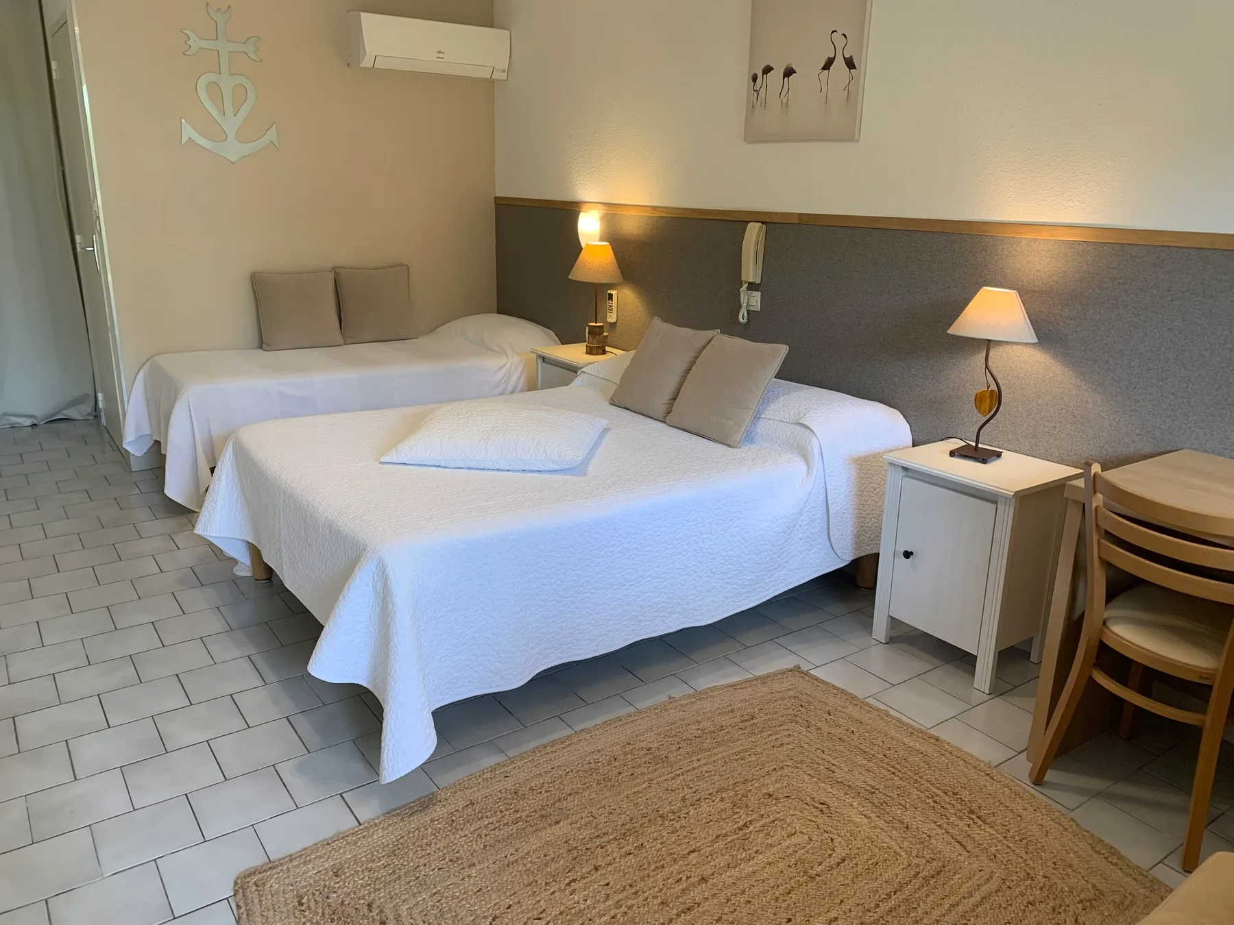 Representative hotel space: A bedroom with two beds, bedside lamps, and a rug.