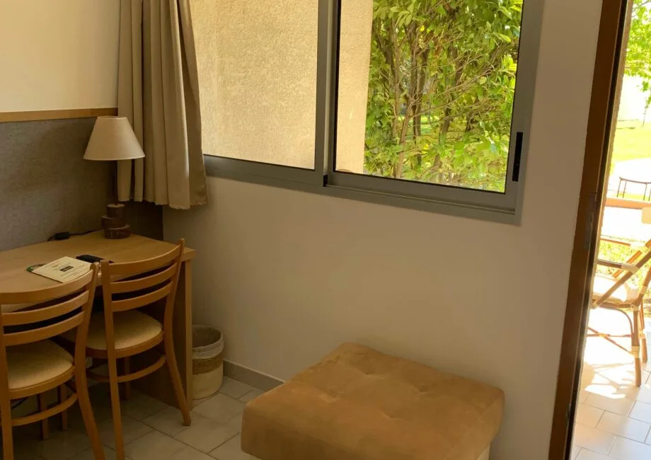 Representative hotel space: A small dining area with a table beside a window overlooking greenery.