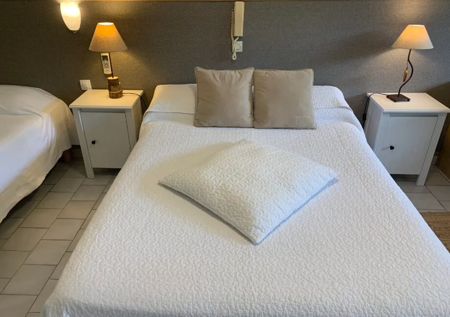 Representative hotel space: A bedroom with two beds and bedside tables topped with lamps.