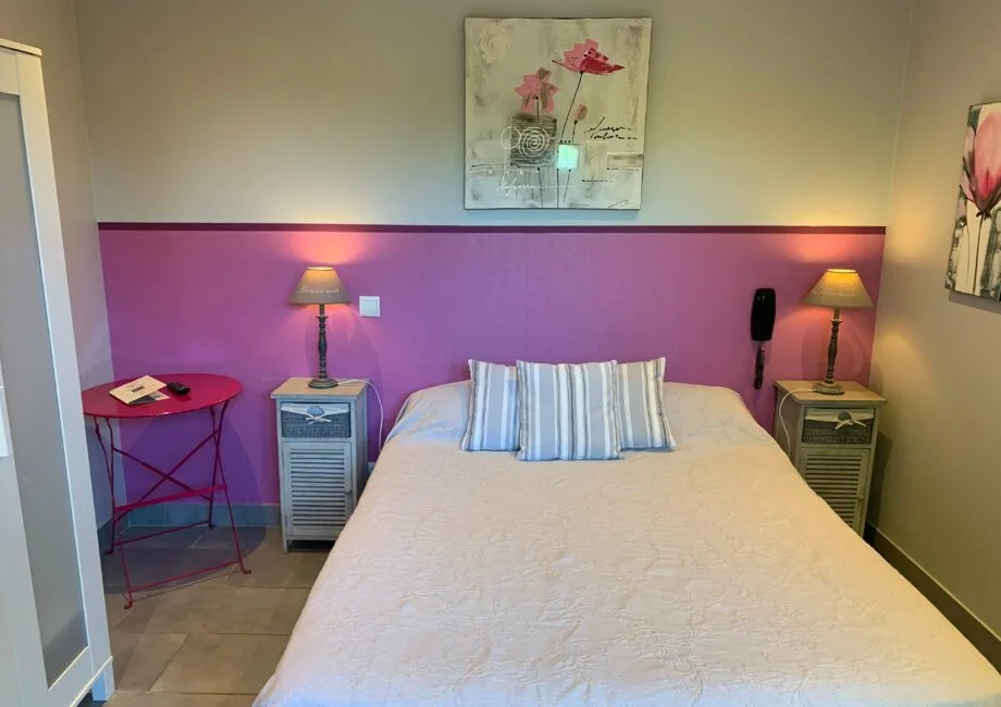 Representative hotel space: A bedroom with a neatly made bed and matching bedside lamps.