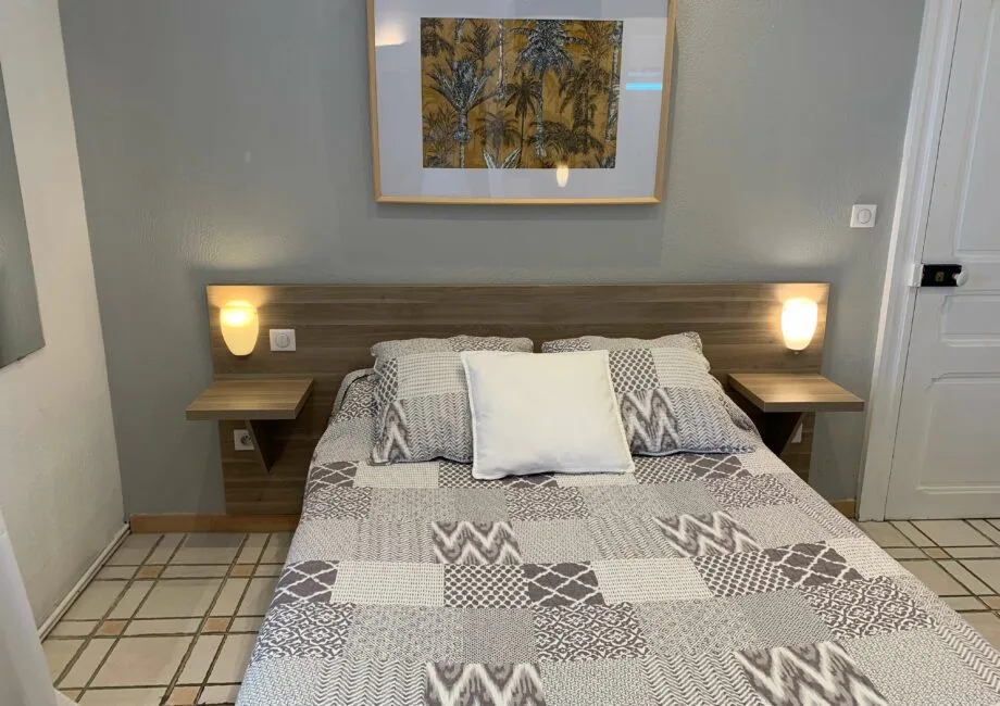Representative hotel space: A bedroom with a patterned bedspread and framed artwork above the bed.