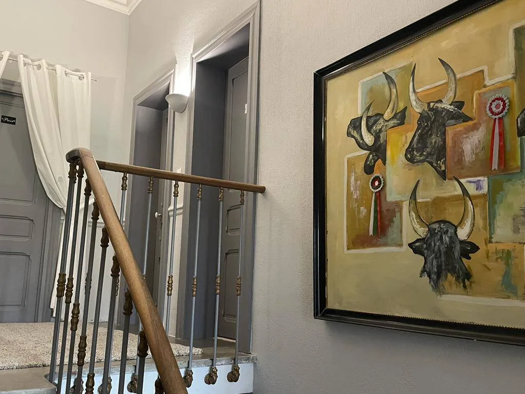 Representative hotel space: An interior stairway with a wooden handrail and framed artwork on the wall.