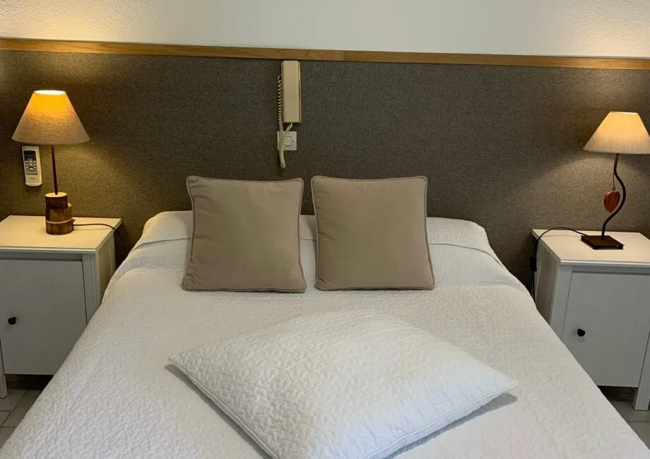 Representative hotel space: A bedroom with a neatly made bed and matching bedside tables.