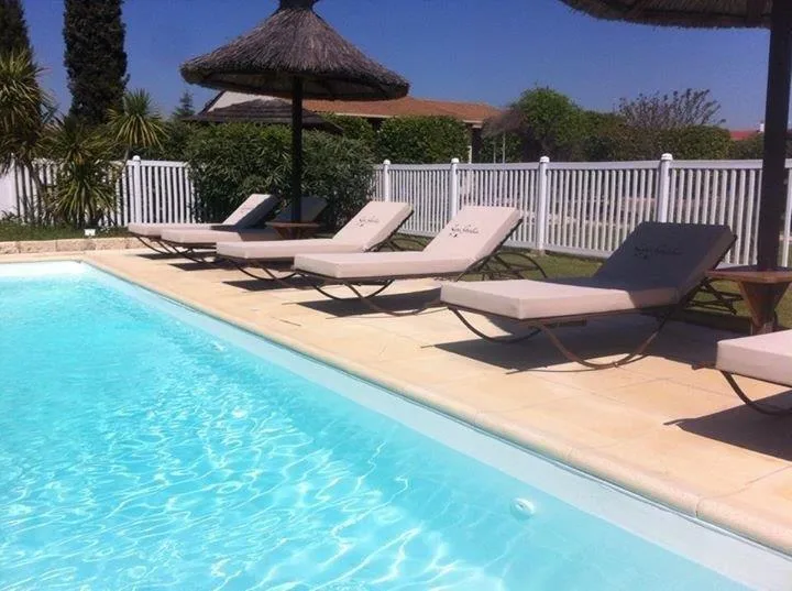 Representative hotel space: An outdoor swimming pool is bordered by lounge seating and shade umbrellas.