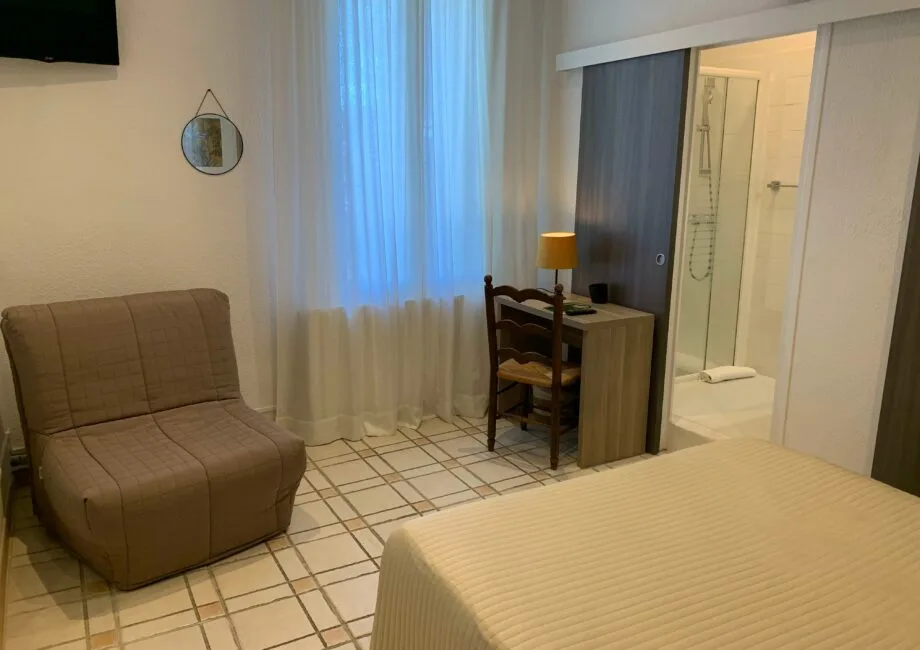 Representative hotel space: A bedroom with a bed, seating, and a desk beside the bathroom.