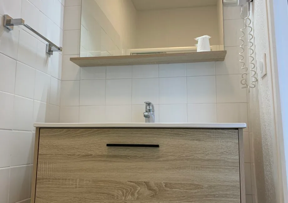 Representative hotel space: Bathroom vanity with a faucet beneath a wall mirror.