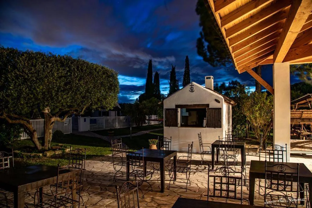 Representative hotel space: An outdoor dining patio with metal tables and a small pavilion at dusk.