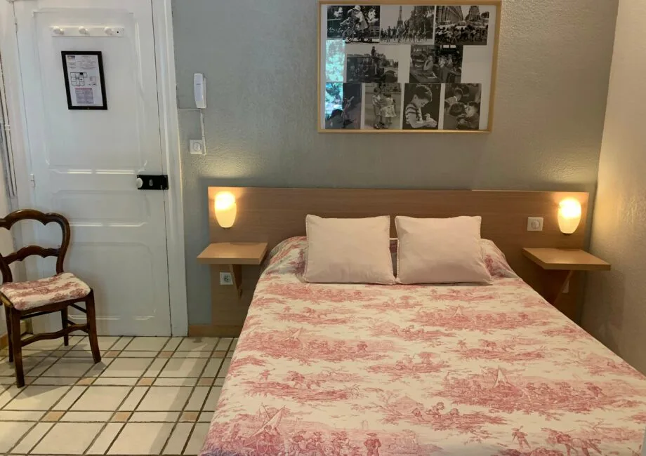 Representative hotel space: A bedroom with a double bed, bedside tables, and framed wall art.