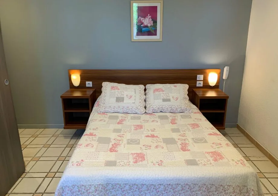 Representative hotel space: A bedroom with a double bed, matching bedside tables, and framed wall art.