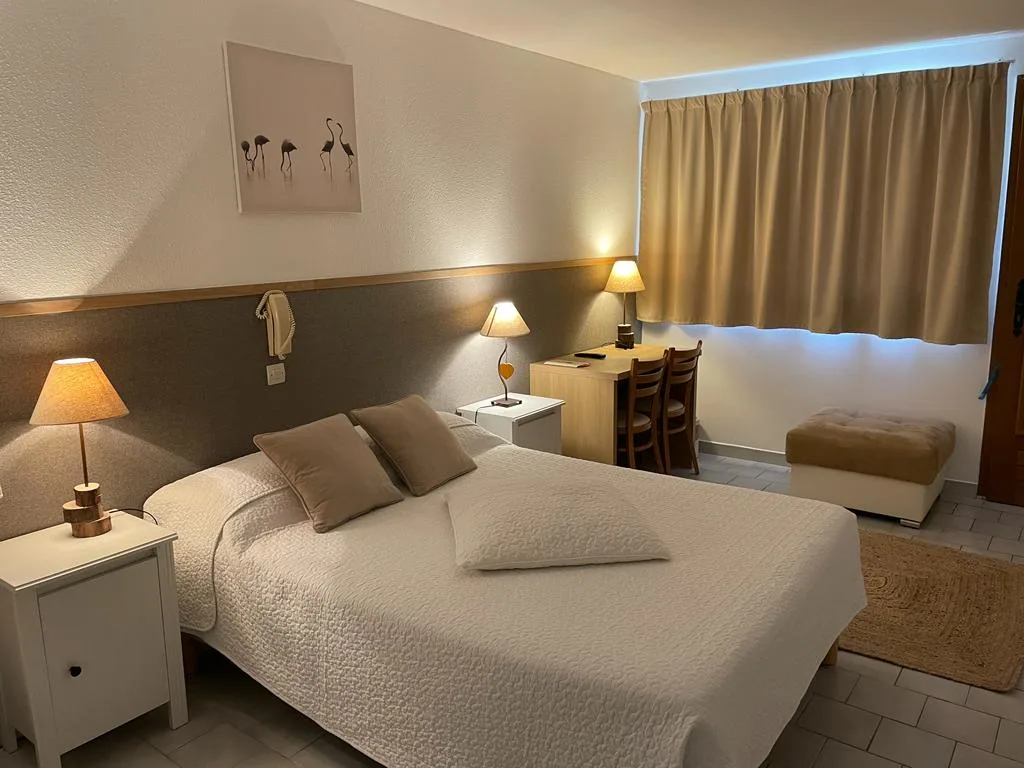 Representative hotel space: A bedroom with a double bed, bedside lamps, and a desk by the window.