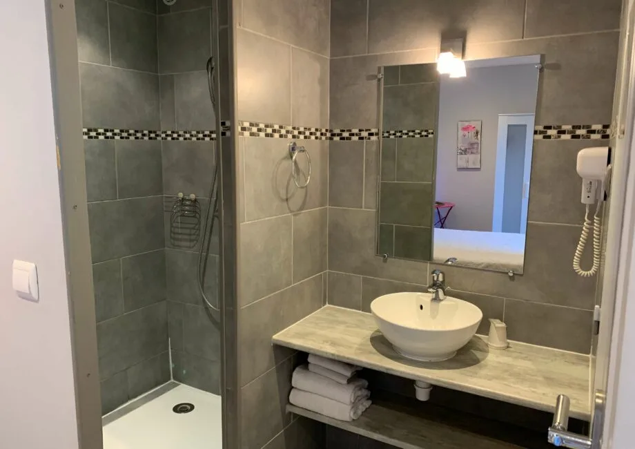 Representative hotel space: Bathroom with a shower, sink, and wall mirror.