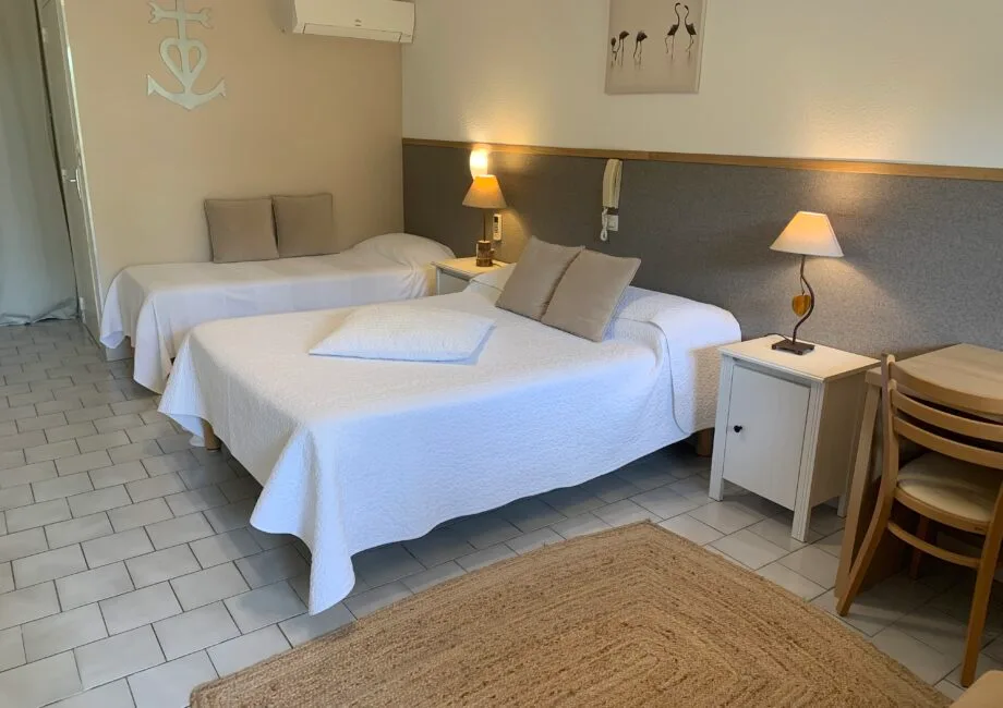 Representative hotel space: A bedroom with two beds, bedside lamps, and a small desk.
