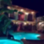 Representative hotel space: An outdoor swimming pool glows beside a landscaped area at night.