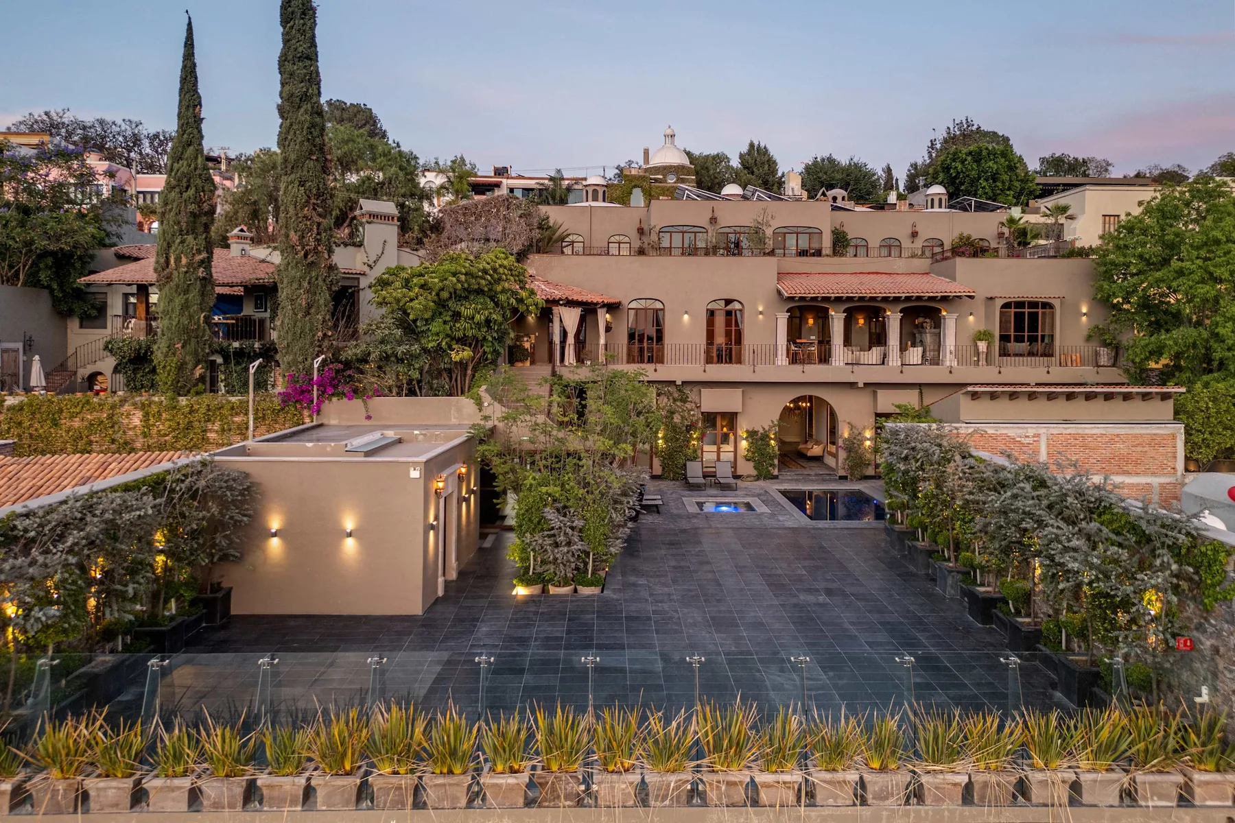 A landscaped courtyard with a paved terrace and a multi-level building in the background.