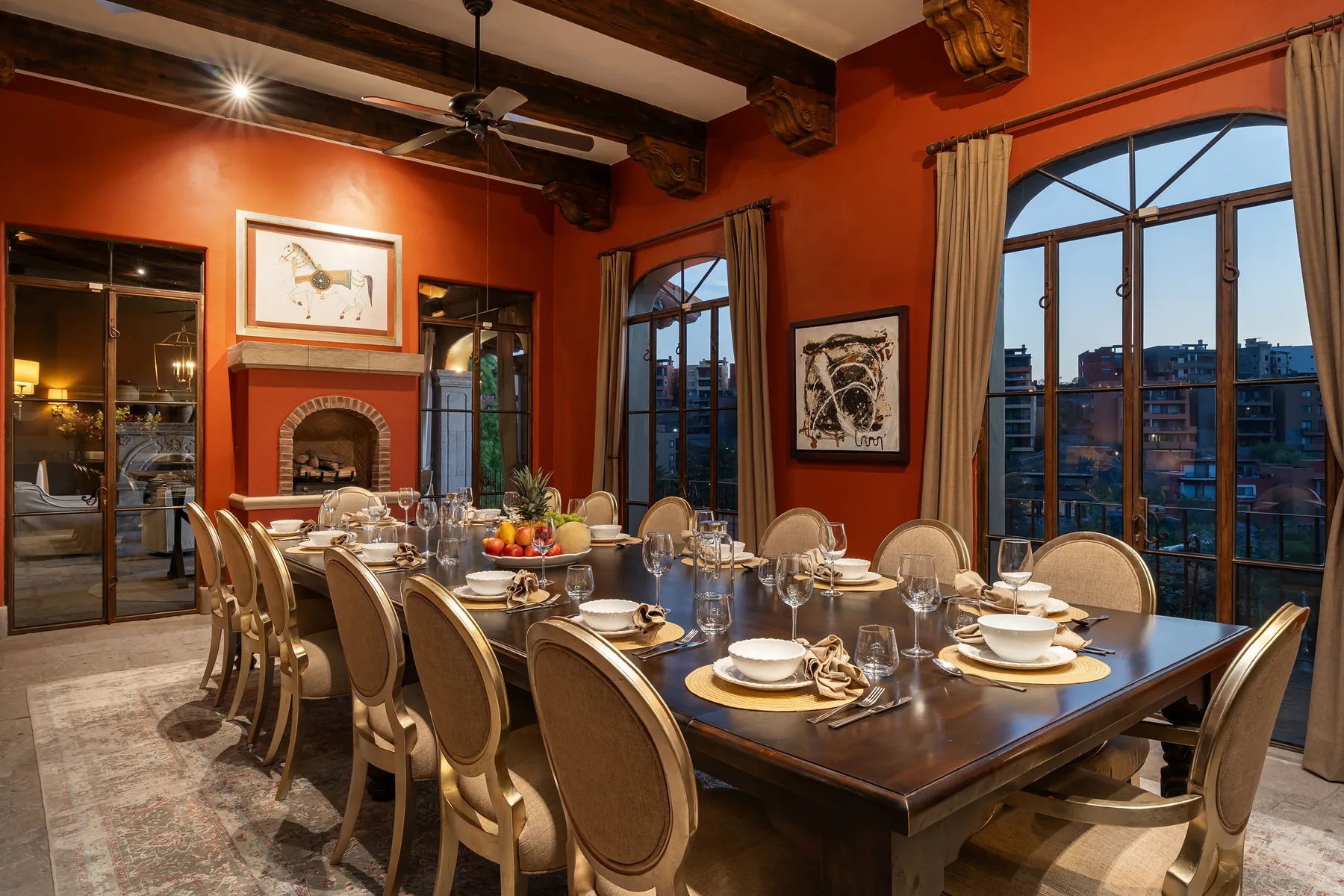 A dining room with a long table set with plates and glassware.