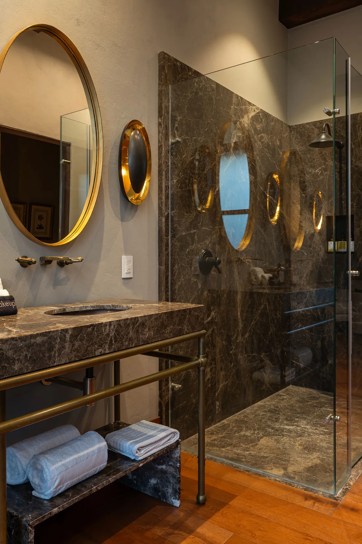 A bathroom with a marble vanity and a glass-enclosed shower.