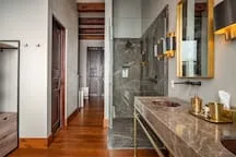 A bathroom with a glass shower beside a long vanity.