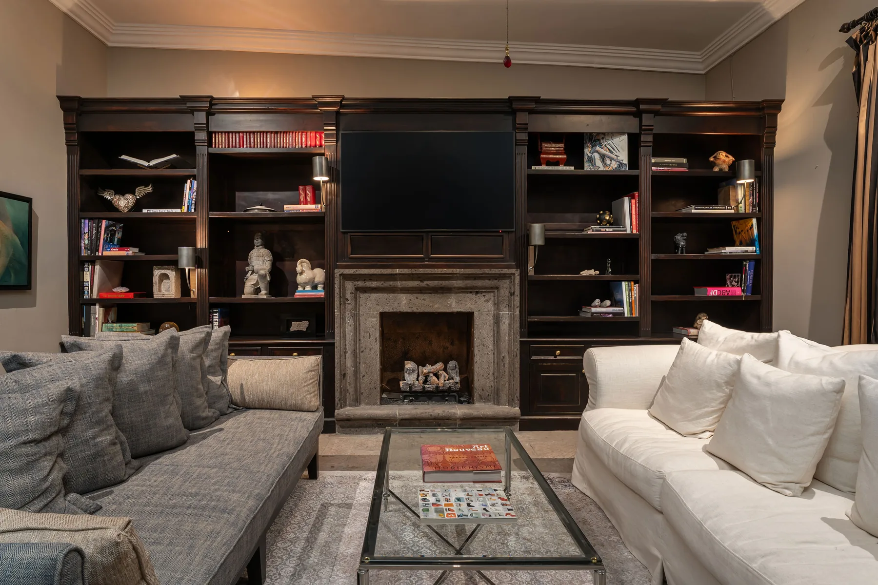 A living room with built-in bookshelves, a fireplace, and seating.