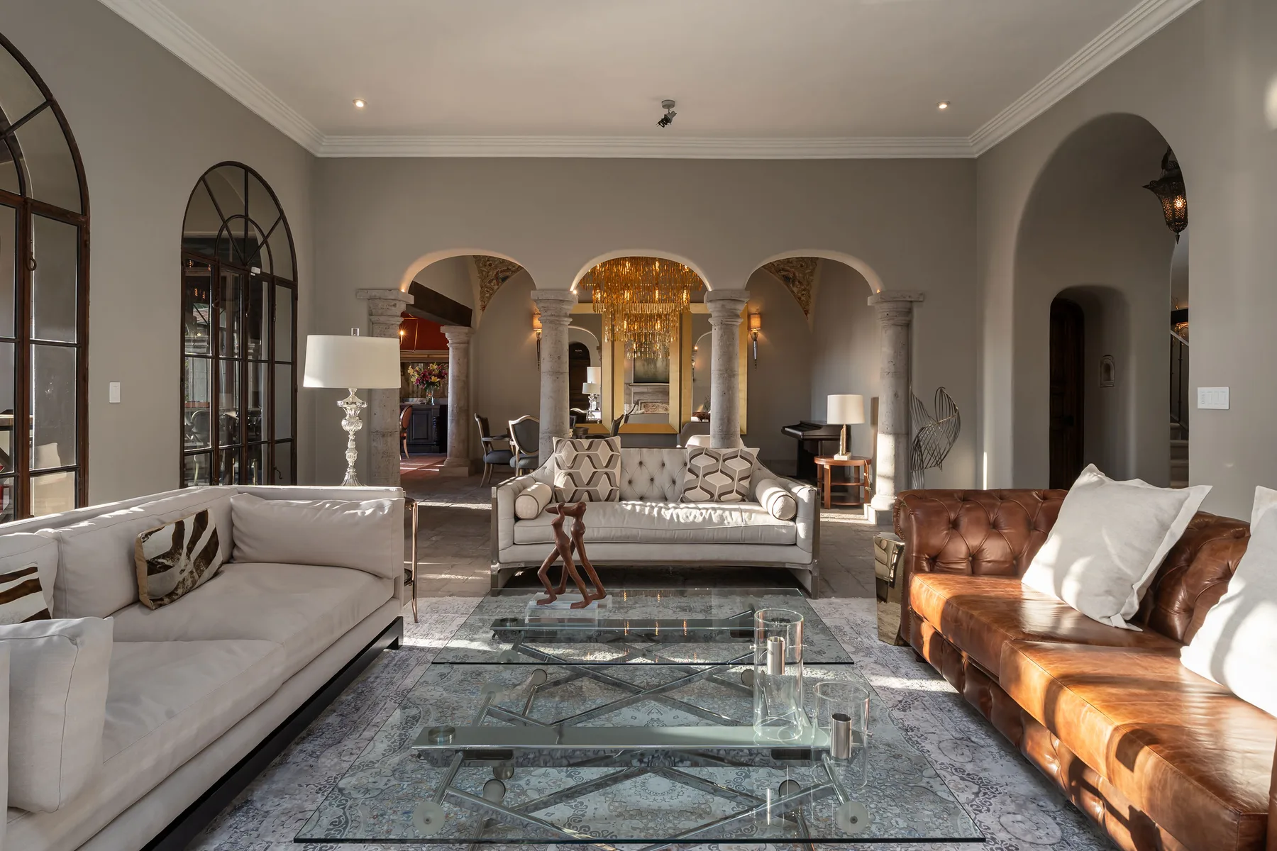 A spacious living room with seating arranged around a glass coffee table.