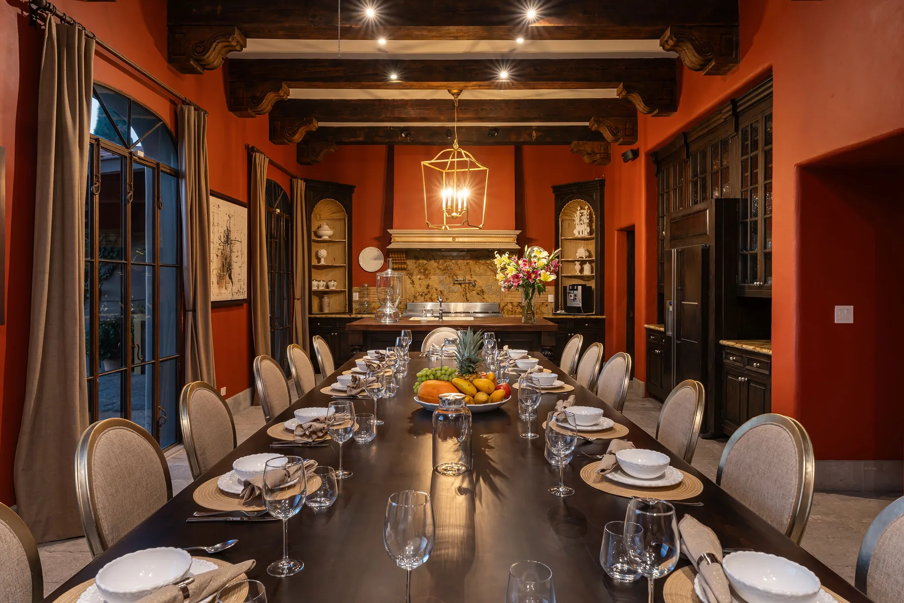 A dining room with a long table set with plates and glassware.