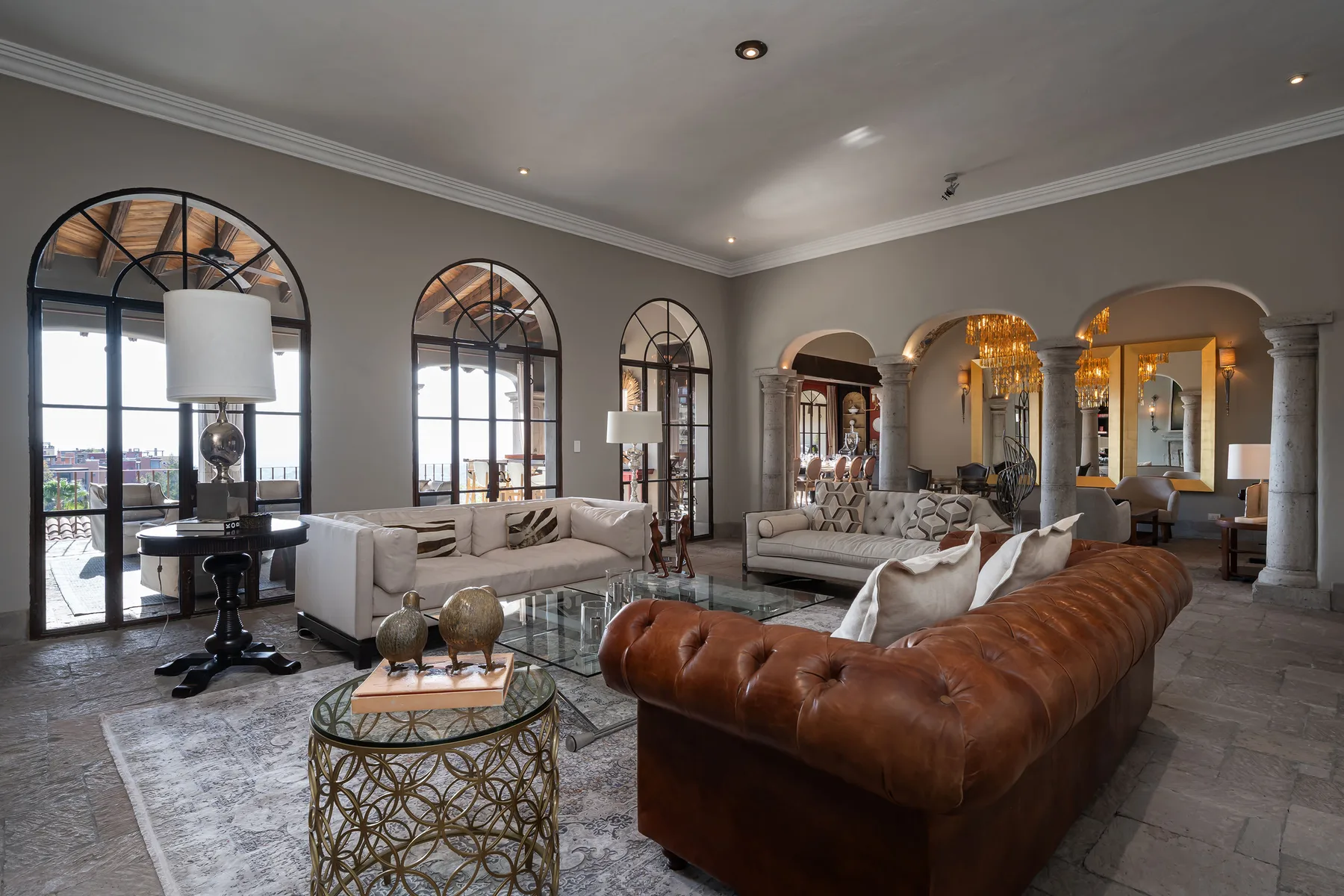 A spacious living room with seating arranged around a glass coffee table.