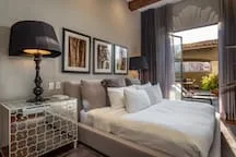 A bedroom with a bed, bedside table, and framed wall art.