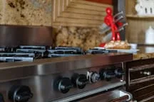 A kitchen cooktop and oven sit beneath a tiled backsplash.