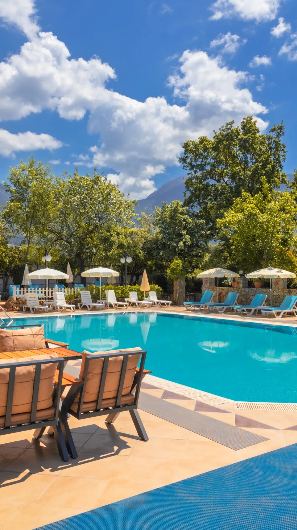 Espacio representativo del hotel: Una piscina al aire libre está rodeada de tumbonas y sombrillas.