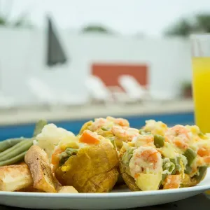 Representative hotel space: A plate of assorted food sits beside a glass of yellow juice.